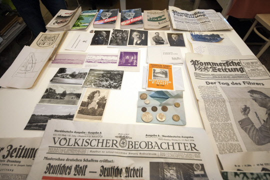 epa05539435 Photographs, newspapers and coins from a time capsule are presented at the National Museum in Szczecin, Poland, 14 September 2016. The time capsule with historic coins, archival German newspapers, pictures, promotion movie of Falkenburg - the old name of Zlocieniec town, and an appeal to the future residents was found couple days ago in Zlocieniec town, north-west Poland. It was buried 80 years ago under the construction of the Ordensburg Krossinsee center that educated future Nazi employees and officers. Documents and other memorabilia will be translated and preserved and then made available to the citizens of Zlocieniec.  EPA/TOMASZ MURANSKI POLAND OUT